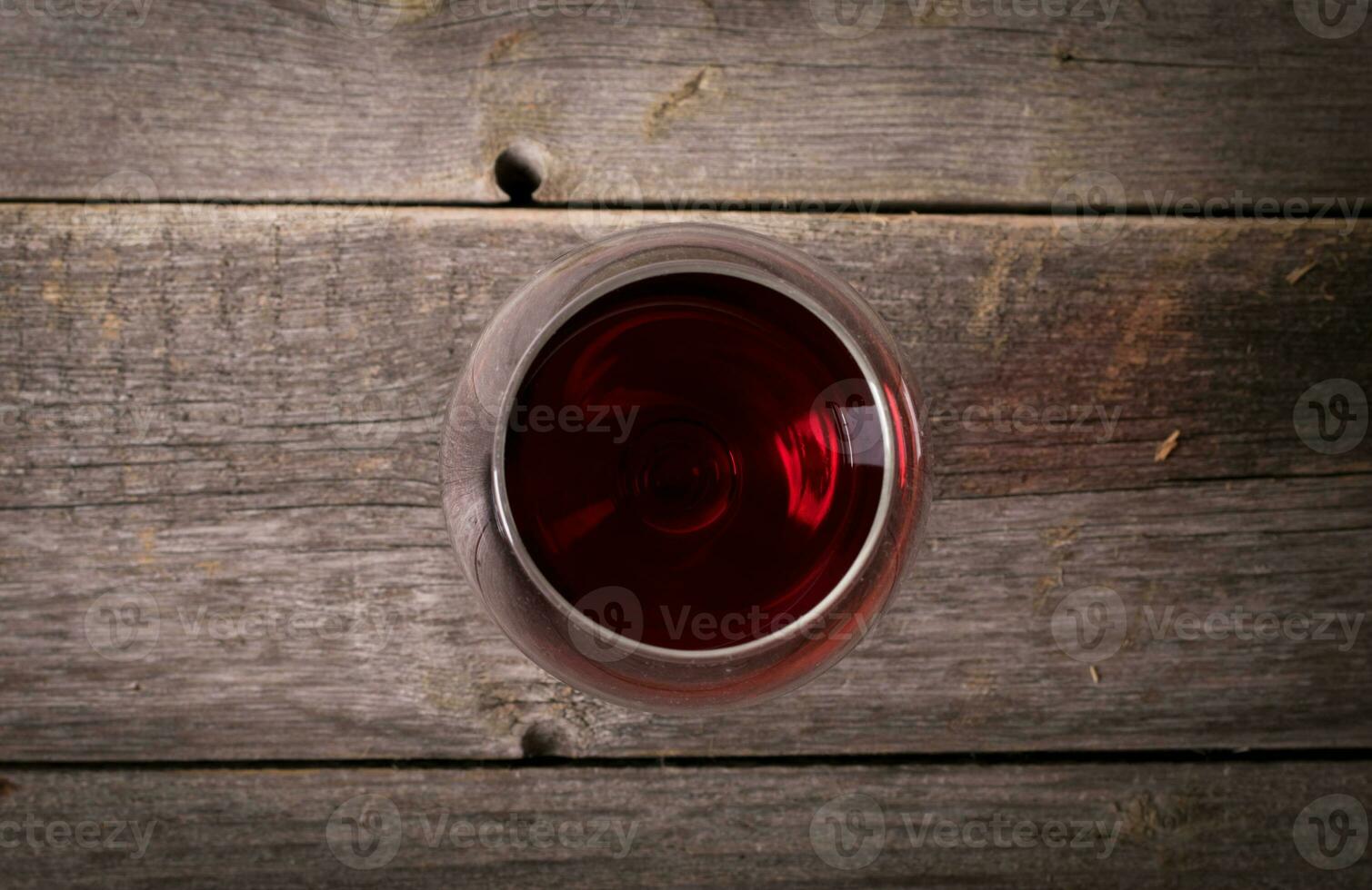 vaso de rojo vino en de madera mesa. ver desde parte superior foto