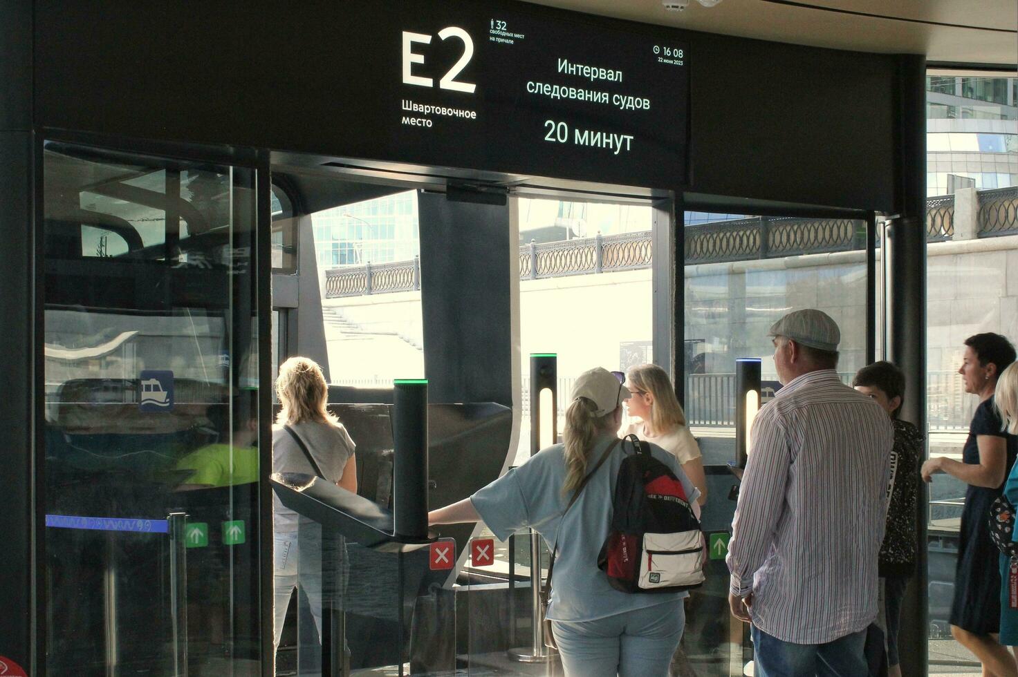 Waiting for boarding to aquabus boat on Moskva River. Electrical ship. Ecological public transport . Green energy in city route. Daily passenger ferry service. Moscow, Russia - June 22, 2023 photo