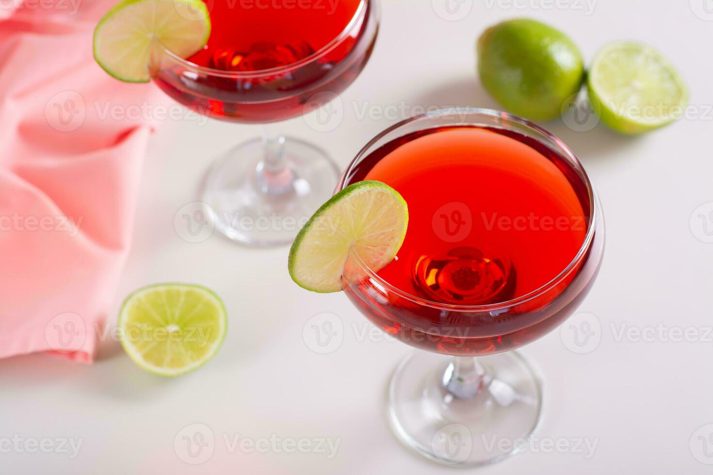 Alcoholic cosmopolitan cocktail in glasses and lime on the table photo