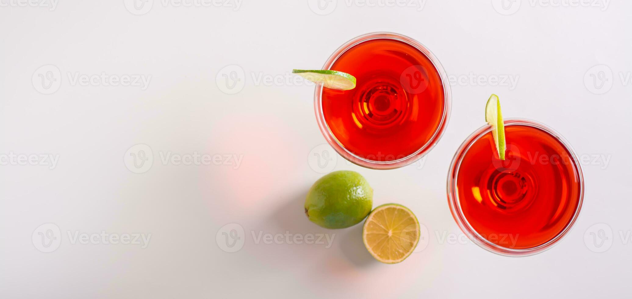Alcoholic cosmopolitan cocktail in glasses and lime on the table top view web banner photo