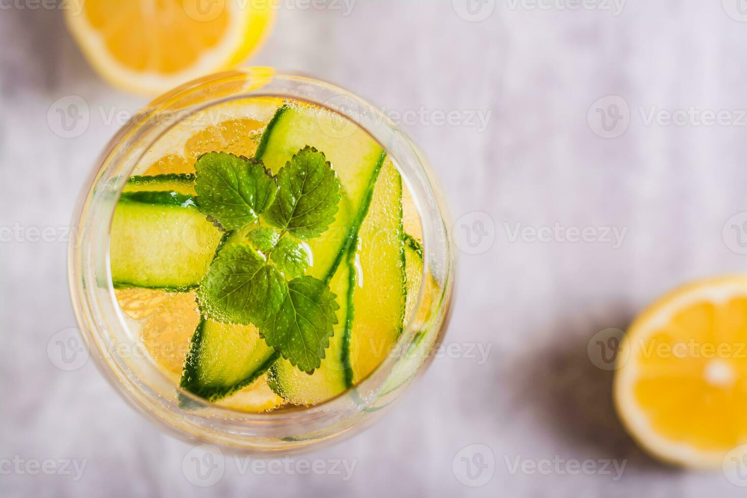 Close up of summer hugo spritz cocktail with champagne, cucumber, lemon and mint in glass top view photo