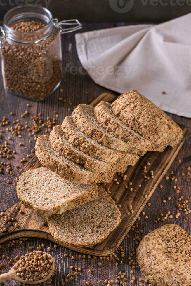 Pieces of homemade buckwheat bread on a cutting board on the table vertical view photo