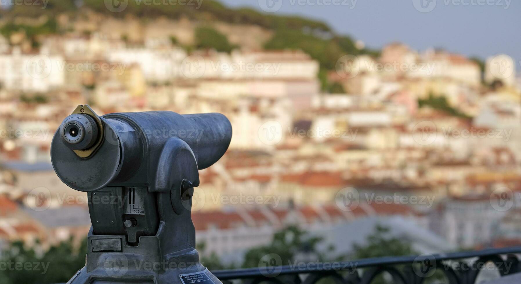 Viewpoint in Lisbon with selective focus on a telescope, with buildings and roof tops in the background photo