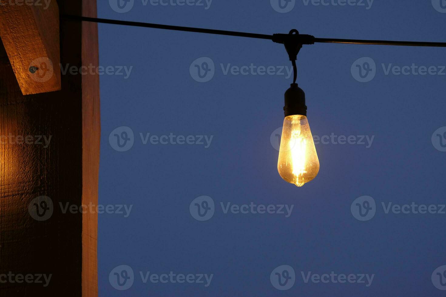 Light bulb against a dark sky at nightfall photo