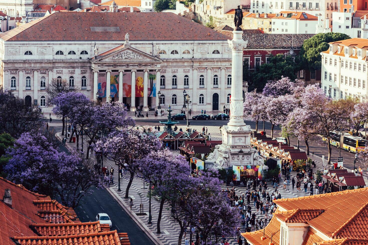 alto perspectiva ver de rossio cuadrado en baixa distrito de Lisboa ciudad, Portugal cubierto con Violeta jacarandá hojas foto