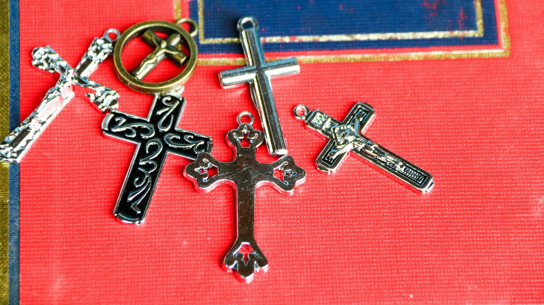 Close up shiny metal cross with black sling on old book to recall the kindness of Jesus Christ for all of Christian photo