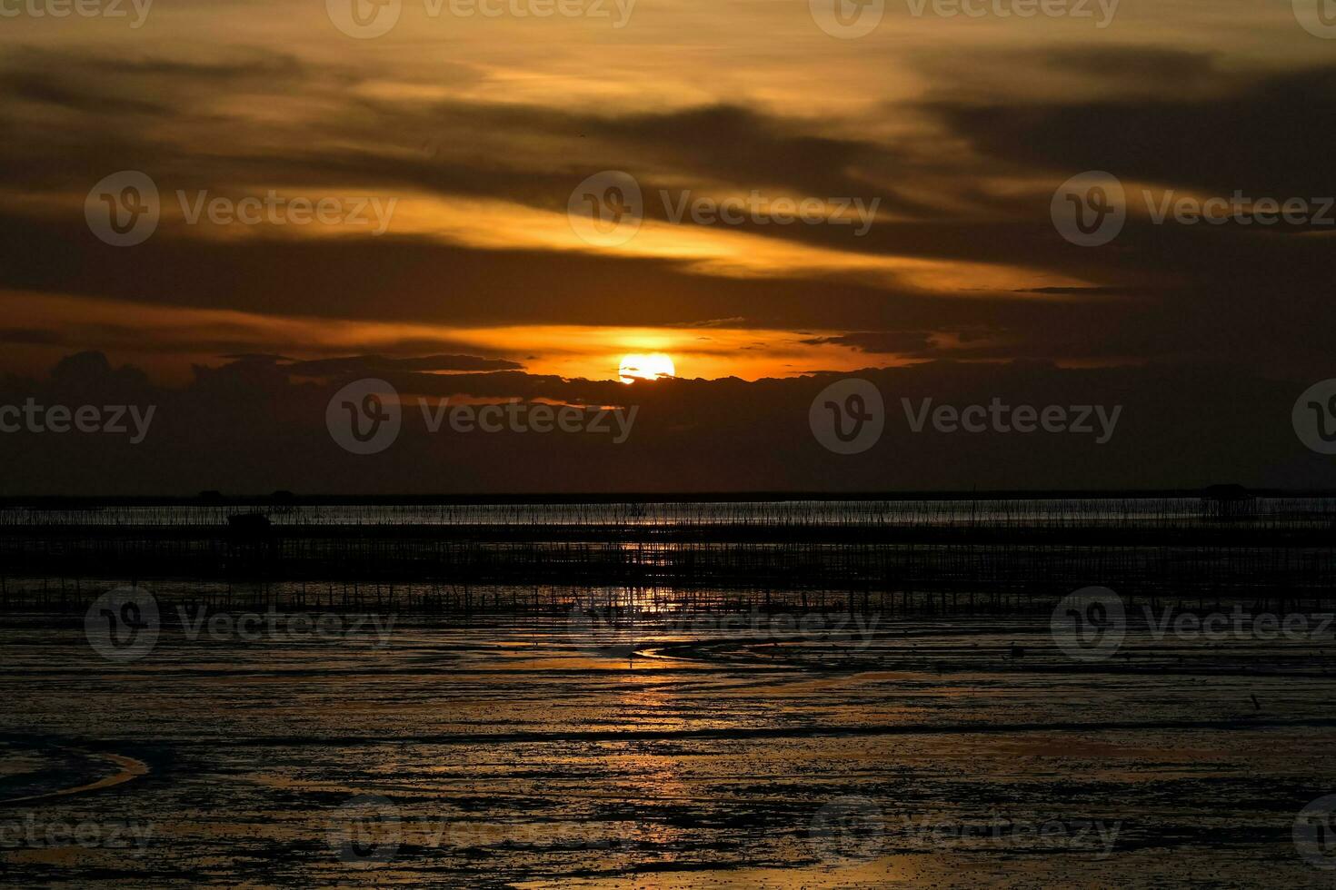 Background Silhouette Evening Sunset of the muddy sea in Thailand photo