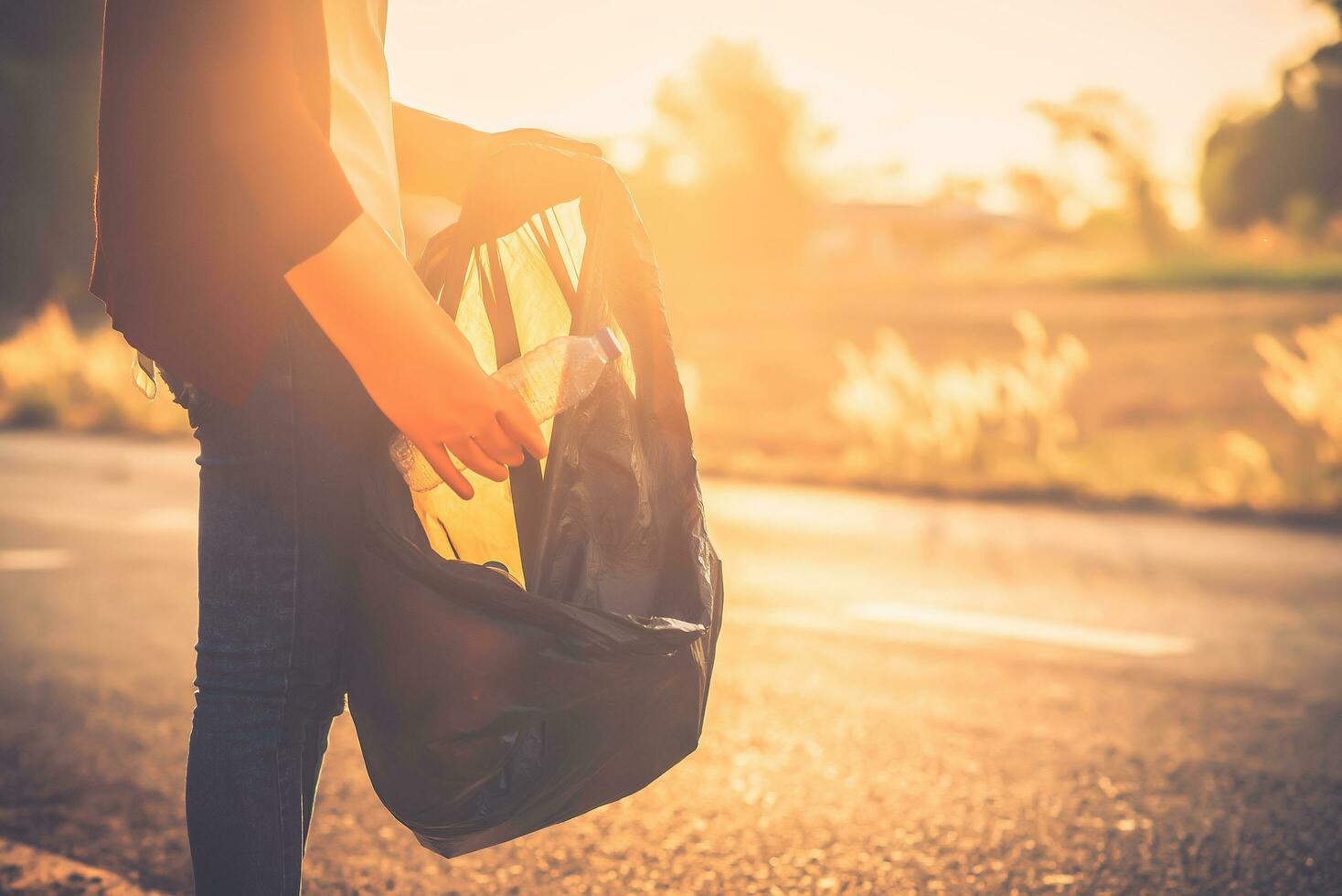 Woman are collecting garbage on the road with the backdrop of the sunset.  Clean up to reduce global warming. photo