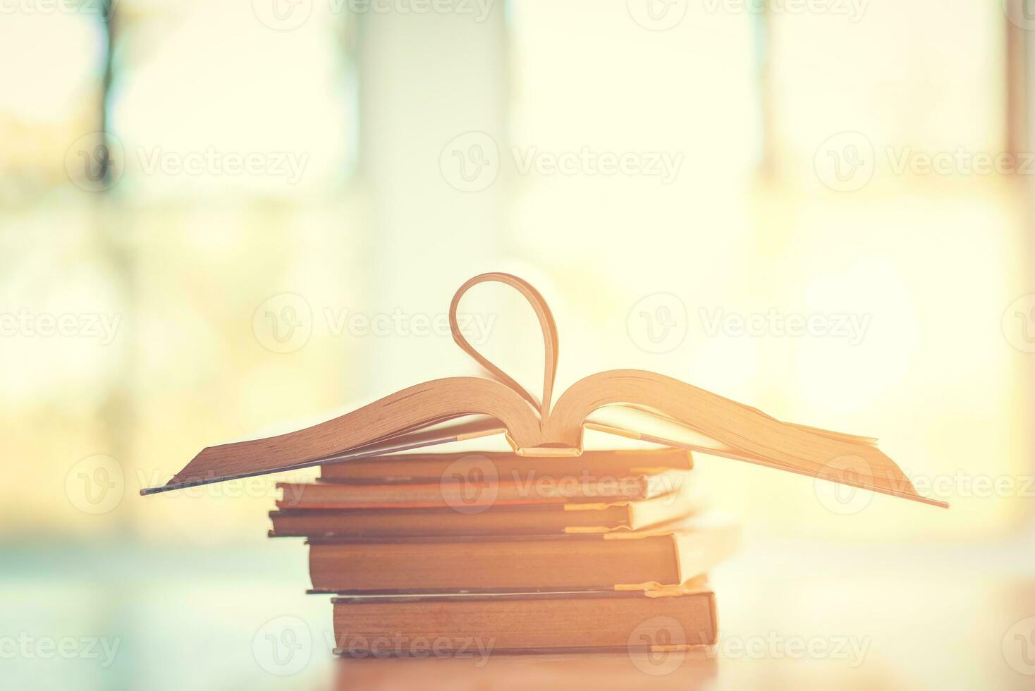 Pile of old books on the table with sunlight and copy space, Stack and one open book, Education learning concept. photo