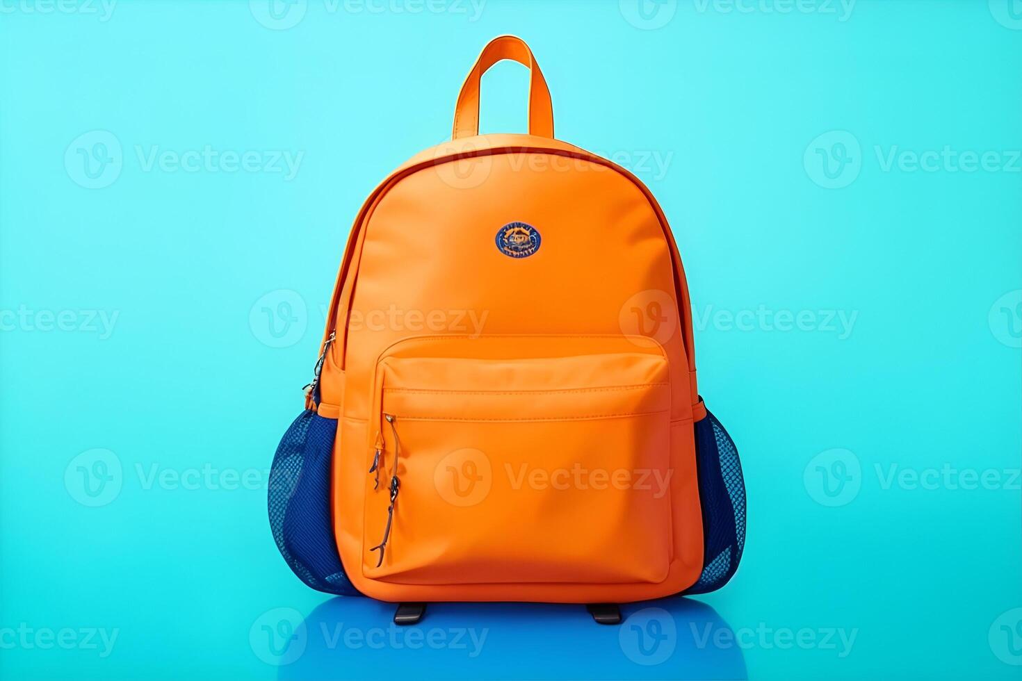 Orange school backpack on blue background, back to school concept with copy space. photo