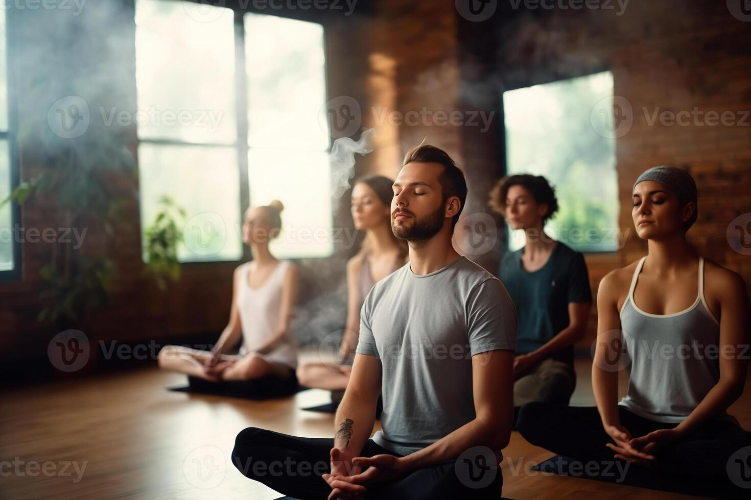Group meditation in yoga studio, breath exercise, men and women