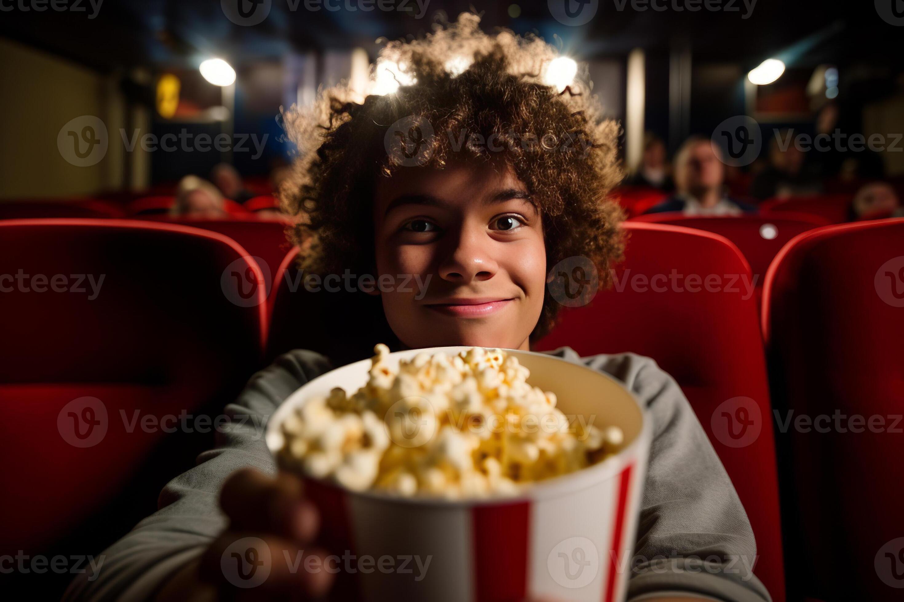 Man eating popcorn in a movie theater, sitting and eating popcorn