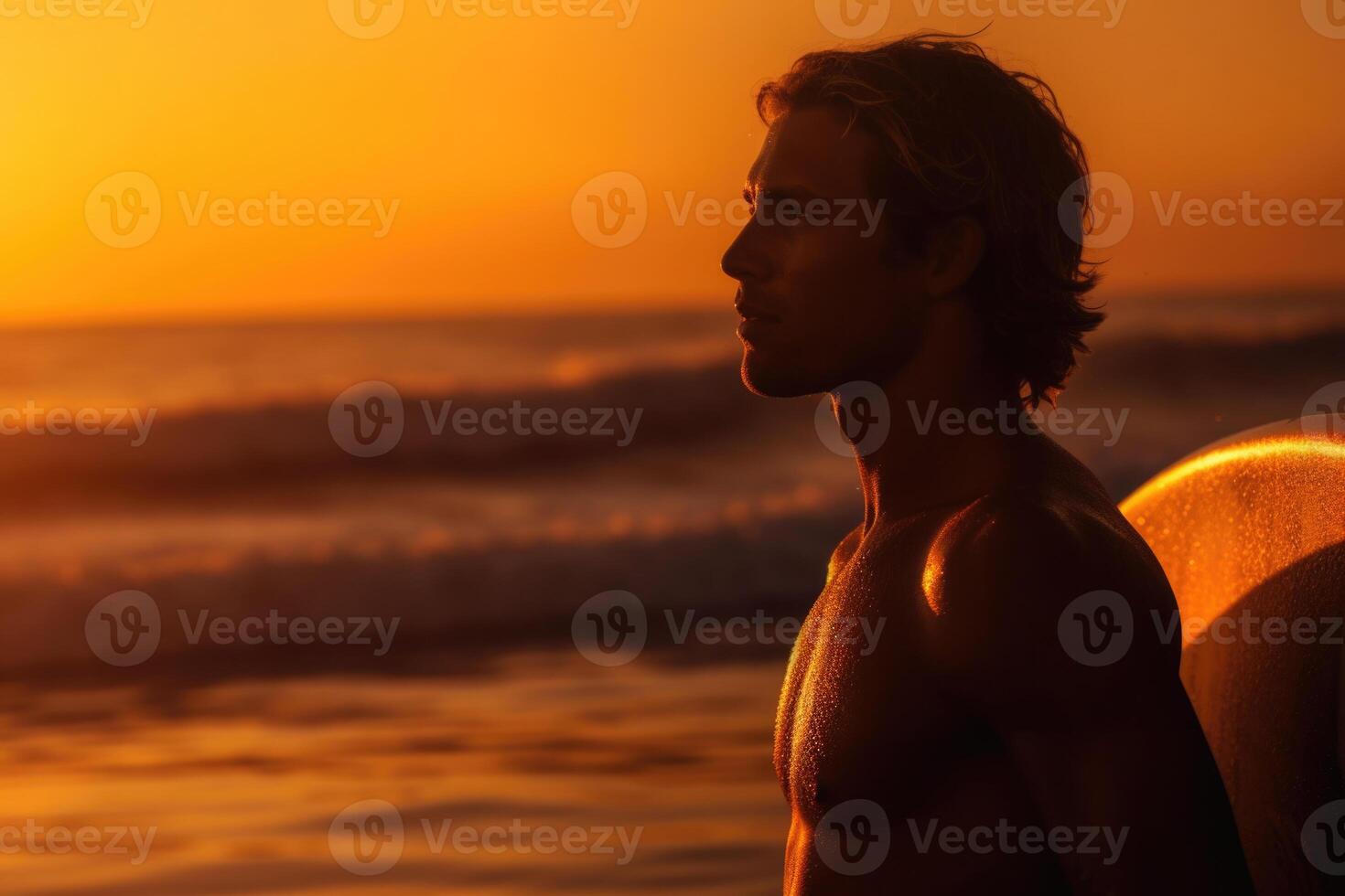 Man with surfboard on sea beach at sunset. photo