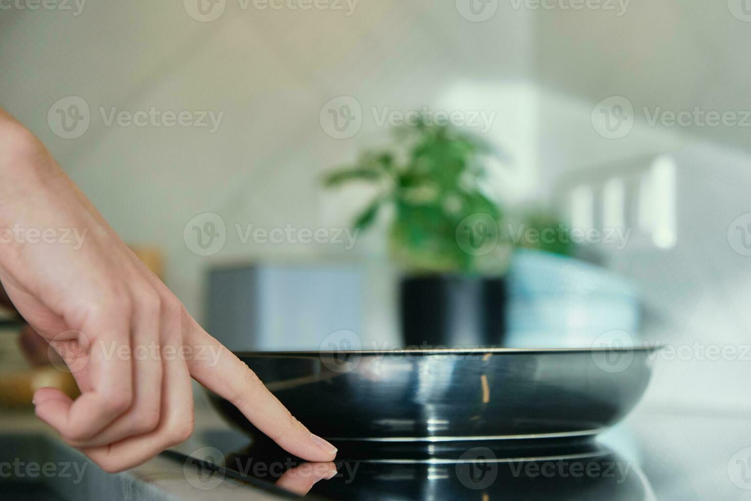 Frying pan on induction hob at kitchen photo