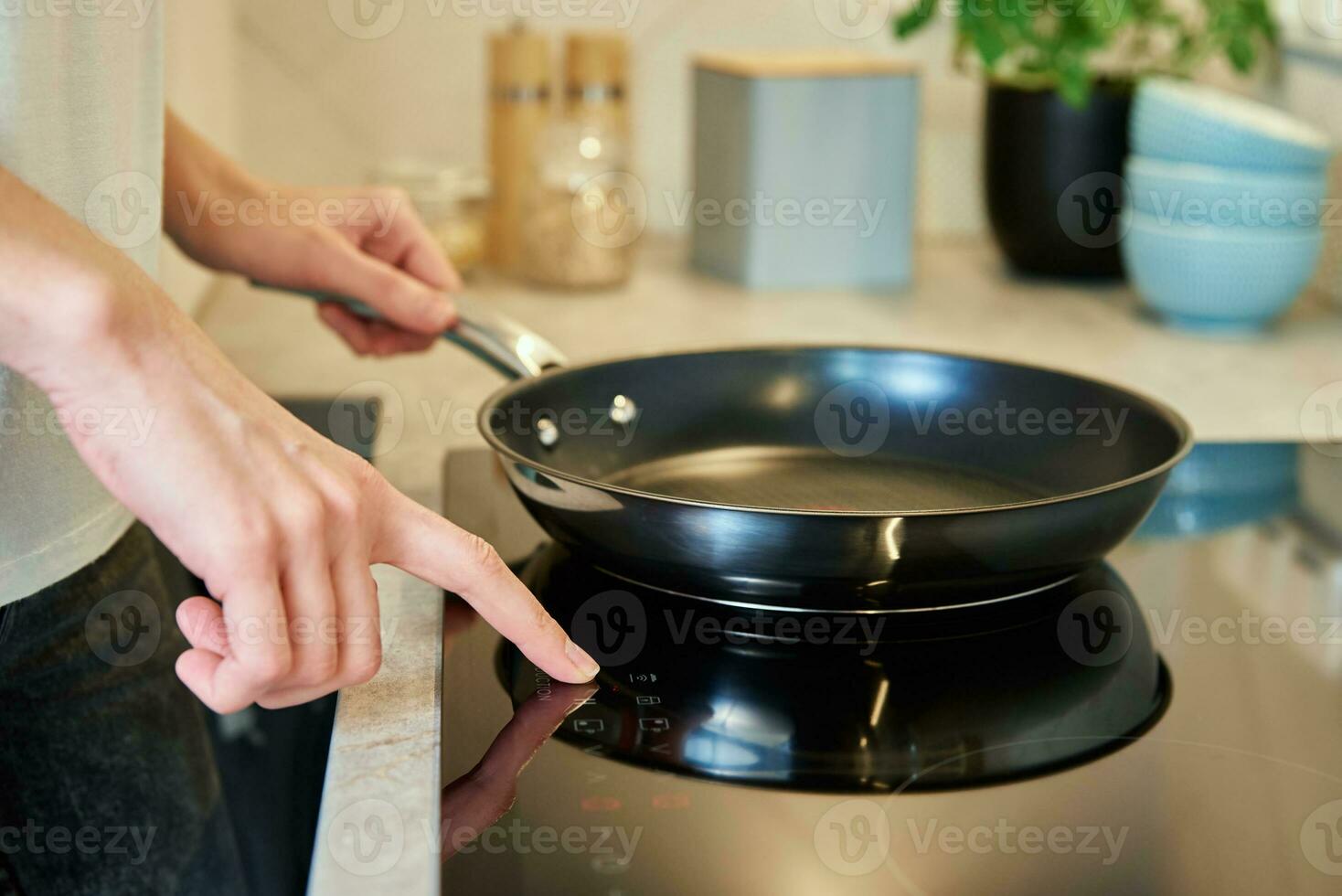 Woman turn on sensor panel on induction stove photo