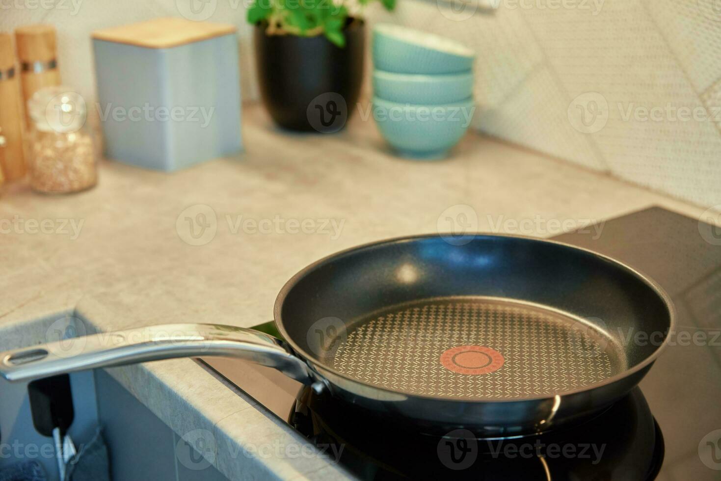 Frying pan on induction hob at kitchen photo