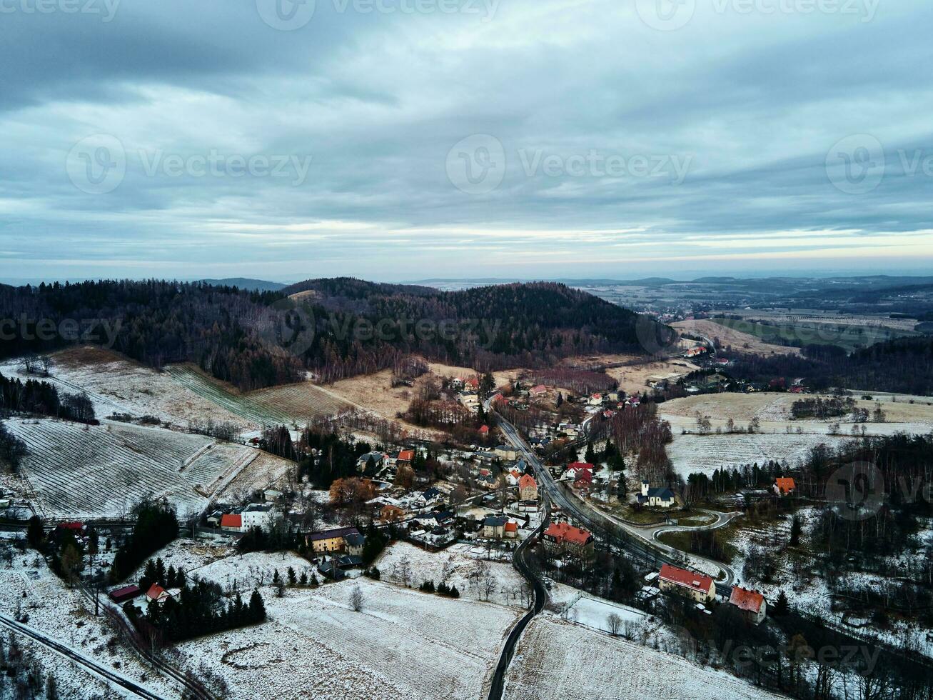 paisaje invernal con mvillage cerca de las montañas foto