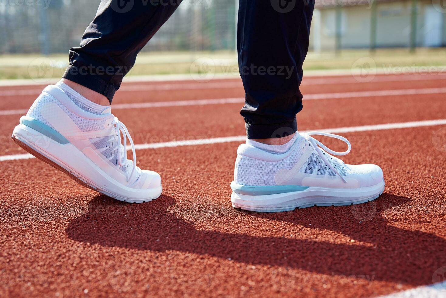 Runner feet running at sport stadium track photo