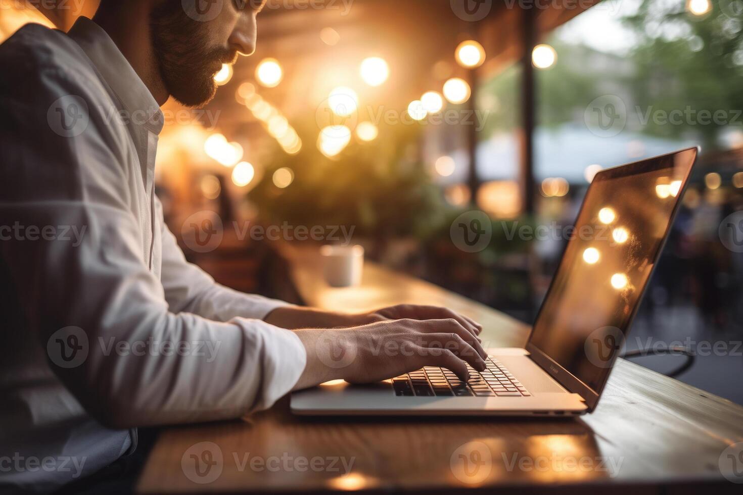 Man working in cafe, using laptop. Typing on keyboard. photo