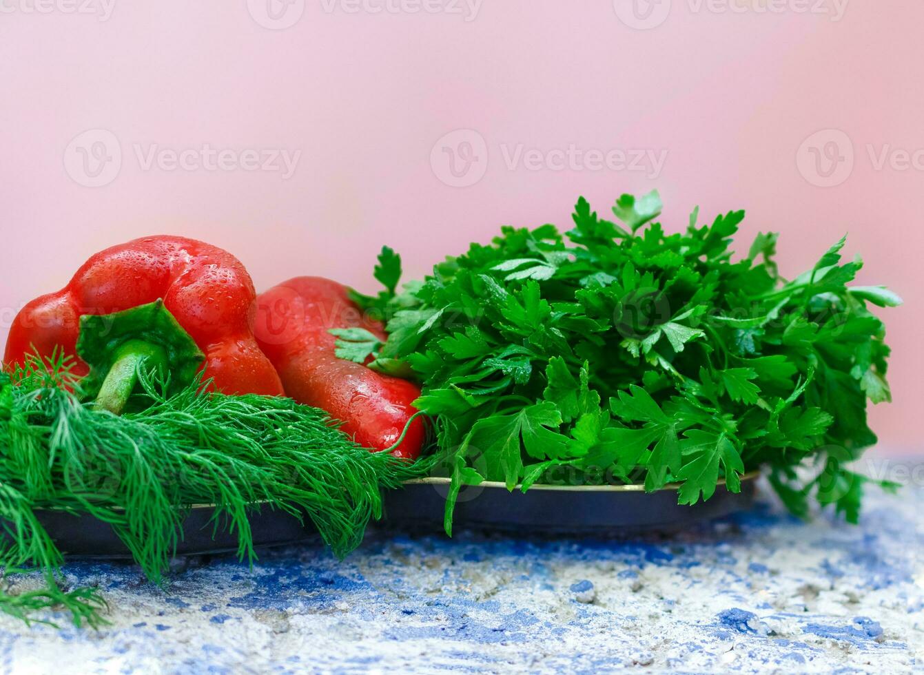 Two red peppers with green dill and parsley on the table. Ingredients for salad or food. Raw vegetables and herbs. Copy space photo