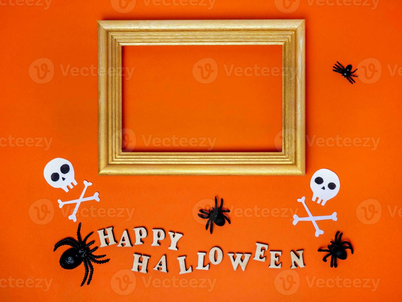 Halloween decorations on an orange background. Trinkets, a Happy Halloween inscription and a frame with a place for text photo