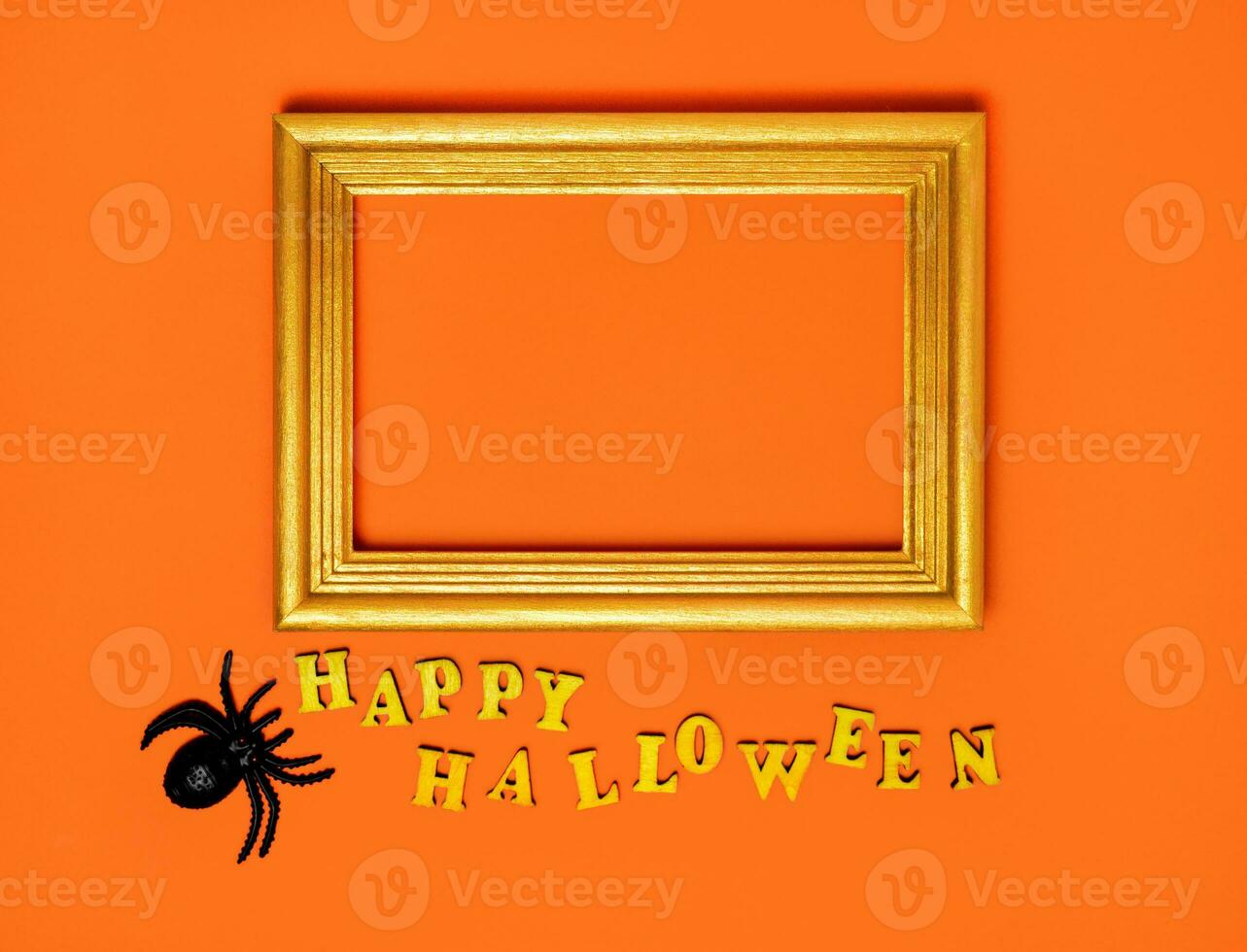 Halloween decorations on an orange background. Trinkets, a Happy Halloween inscription and a frame with a place for text photo