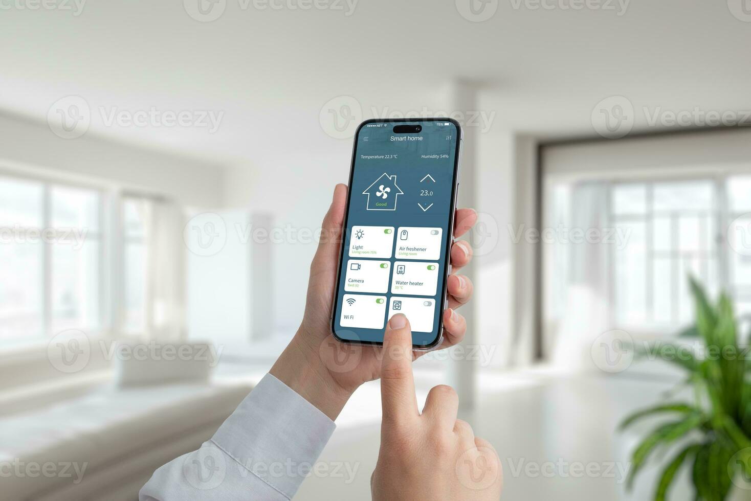 Person controls the temperature and lighting in the house with the help of an app on a mobile phone. A modern smart home application with the most important smart controls photo