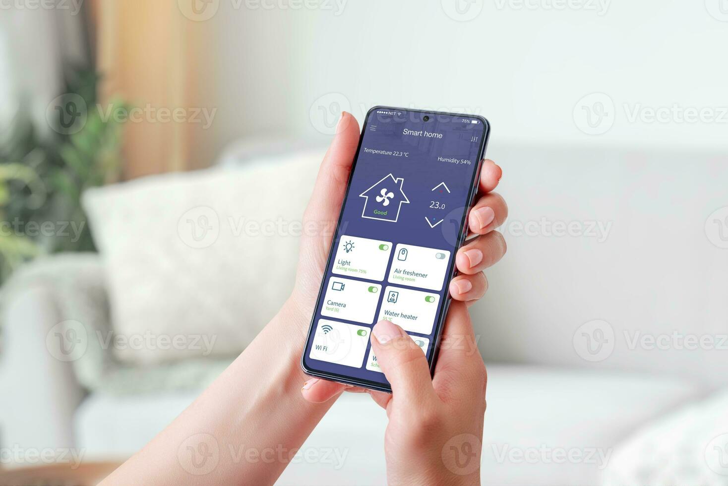 Woman's hand holding a mobile phone, showcasing a smart home app. Smart living concept. Decorated living room in background photo