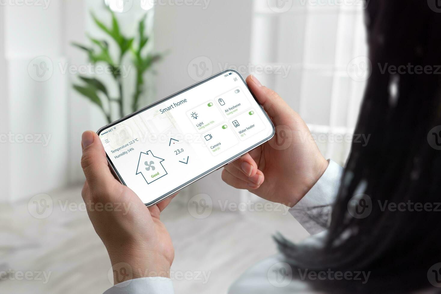 Modern living as a woman effortlessly manages her smart home using a mobile phone, living room backdrop photo