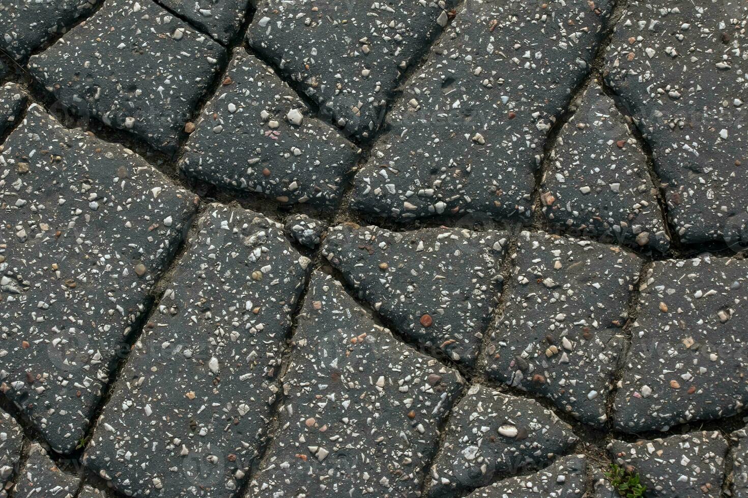 A network of black cracks on the asphalt surface. Road texture with weathered surface, showcasing the effects of time and wear. photo