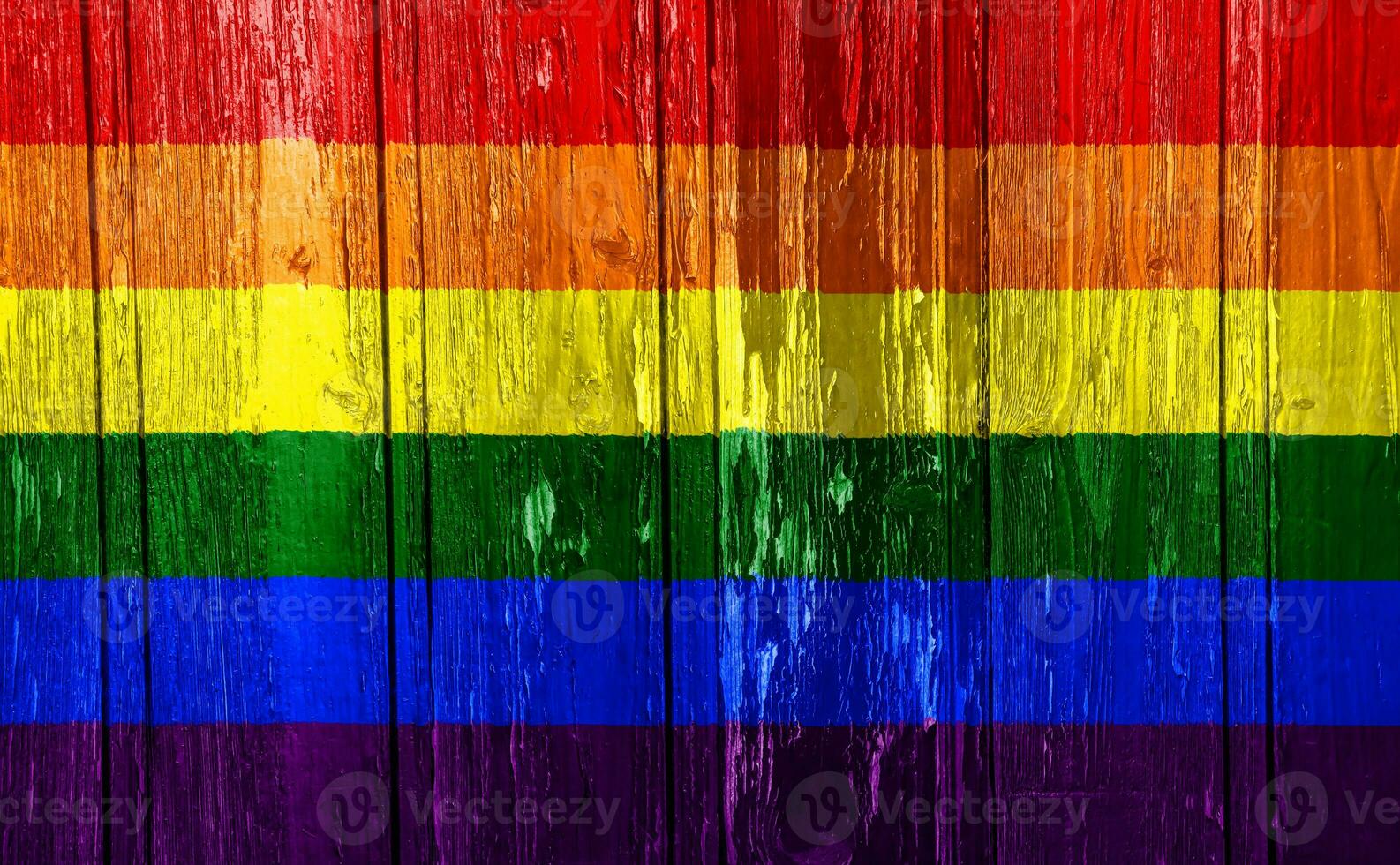 Flag of the LGBT community on the background of the wooden texture of the boards. Rainbow gay culture symbol. Concept collage. photo