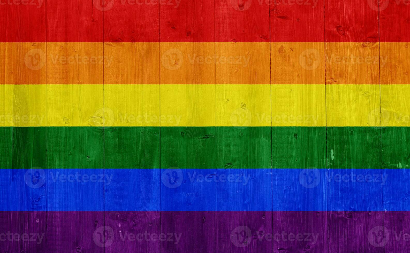Flag of the LGBT community on the background of the wooden texture of the boards. Rainbow gay culture symbol. Concept collage. photo