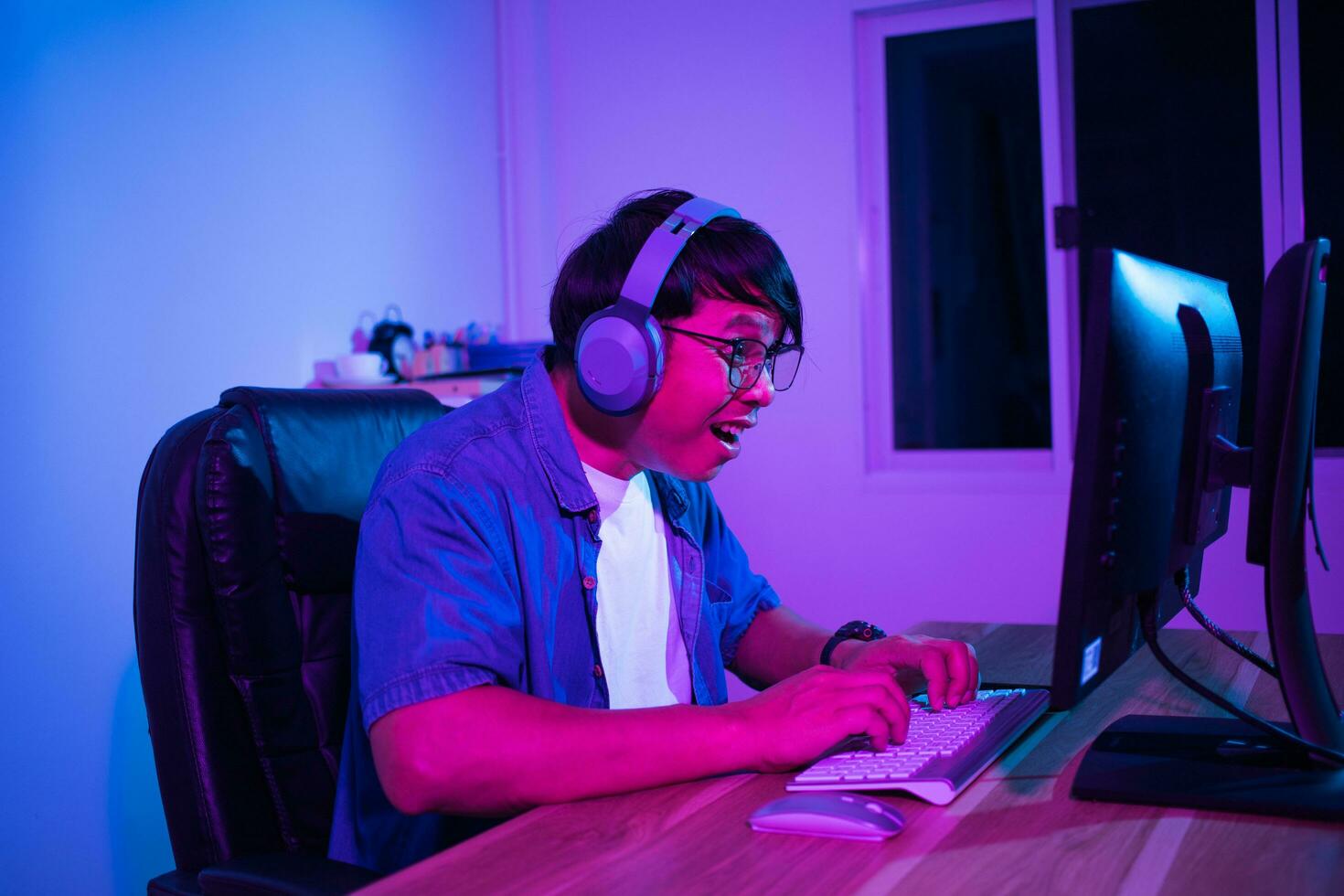 Asian man playing games at home at night photo