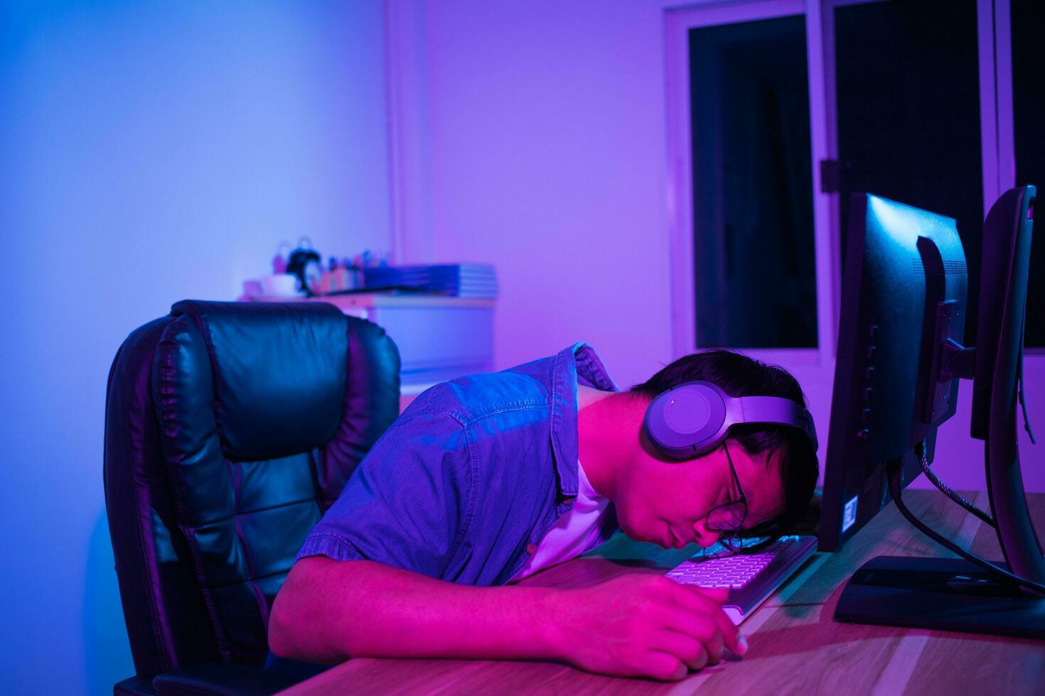 Asian man playing games at home at night photo