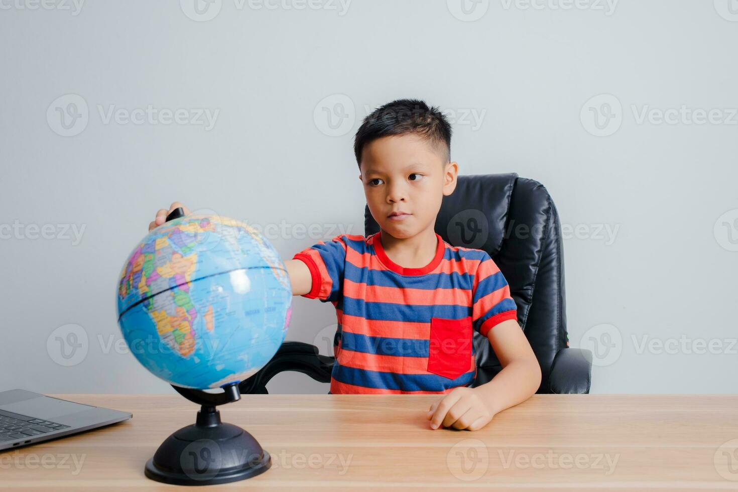 Asian boy looking at world map photo