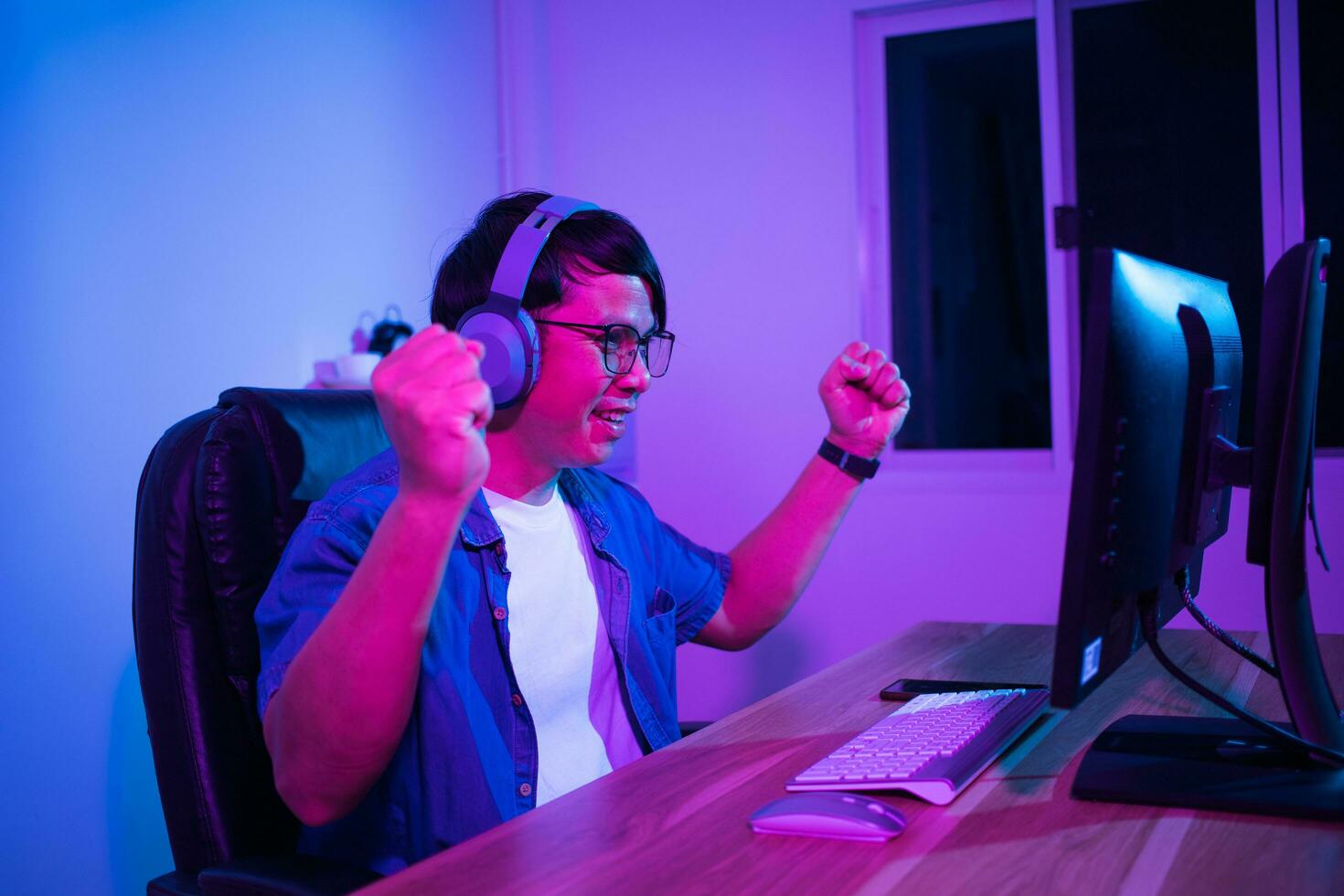 Asian man playing games at home at night photo