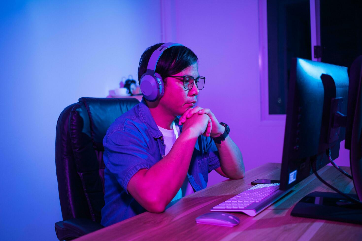 Asian man playing games at home at night photo