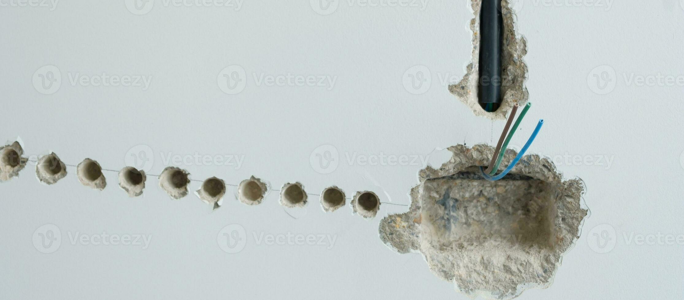 Electrical Wiring under plaster, hidden installation cables for socket to a concrete. Renovation, Repair and development of home and apartment concepts photo