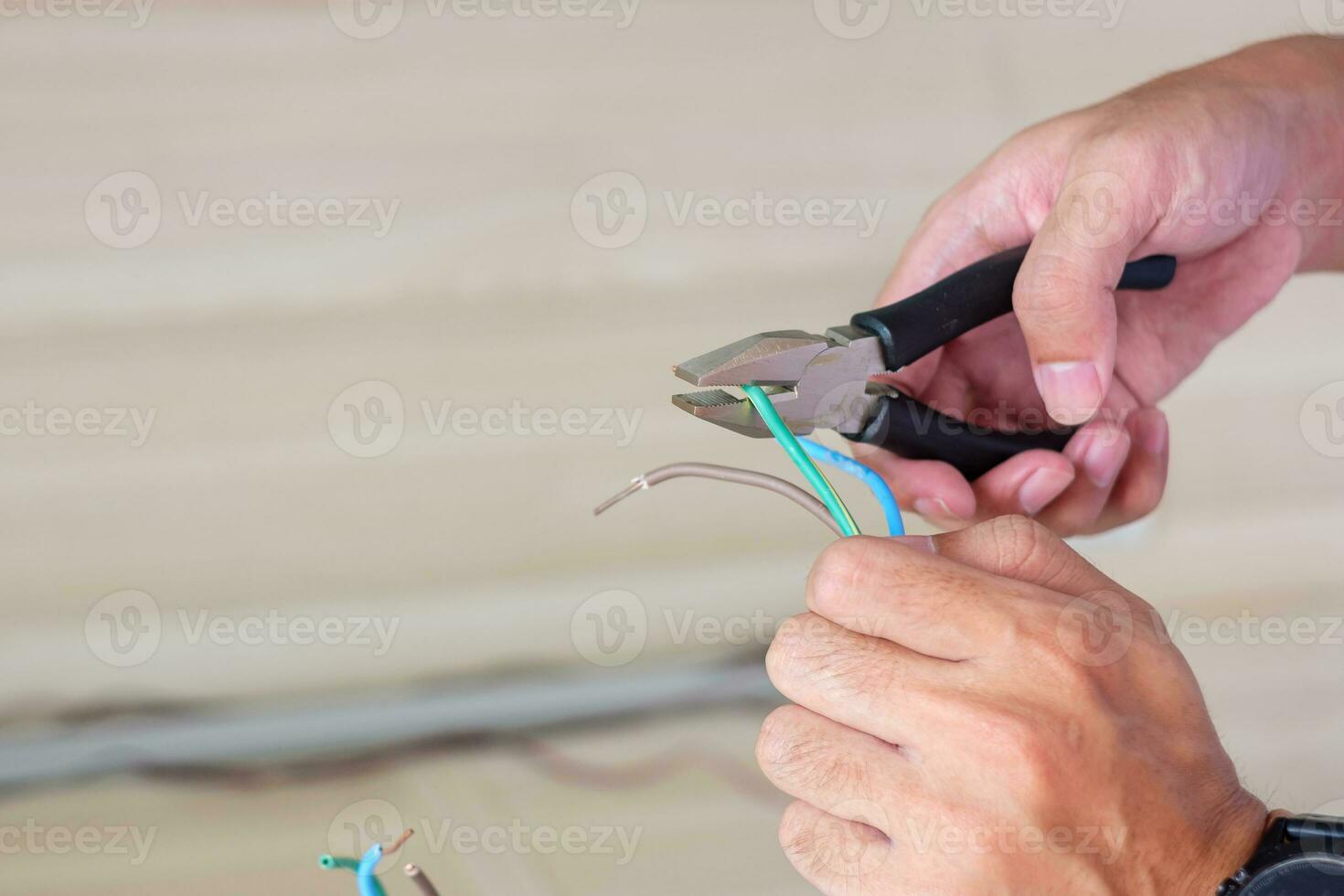 Electrician cuts electrical wires with pliers, Wiring cables installation for socket plug. Fixing, Renovation, Repair, service and development of home and apartment concepts photo