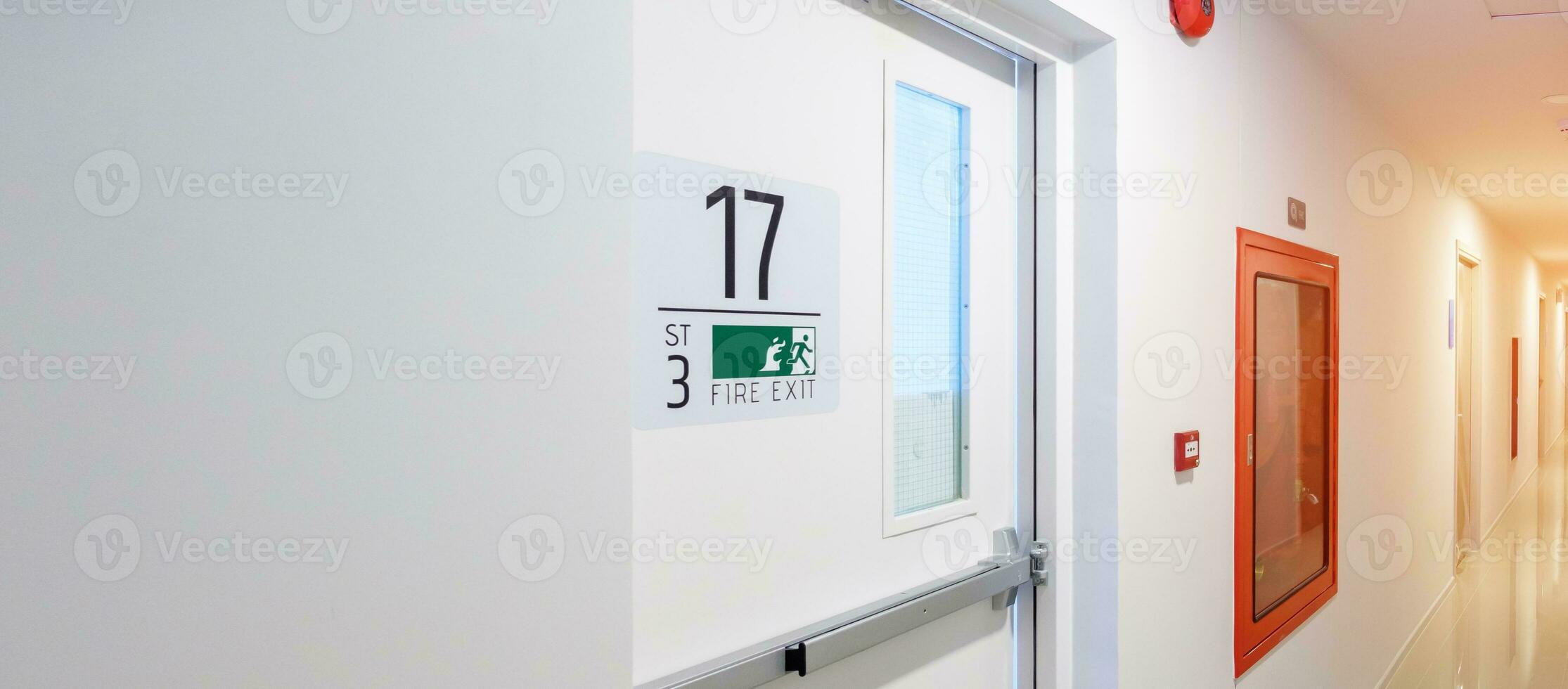 Fire extinguisher system on the wall with Fire Exit door sign for emergency. Stairwell fire for escape in building or apartment photo