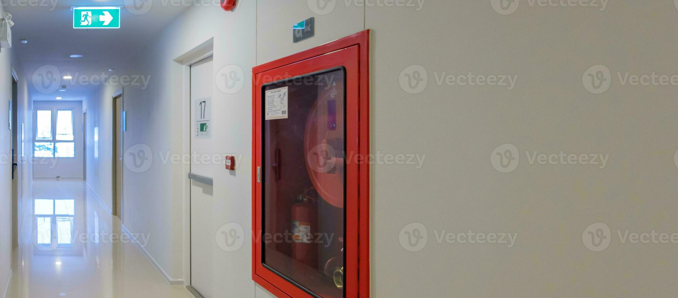 Fire extinguisher system on the wall with Fire Exit door sign for emergency. Stairwell fire for escape in building or apartment photo