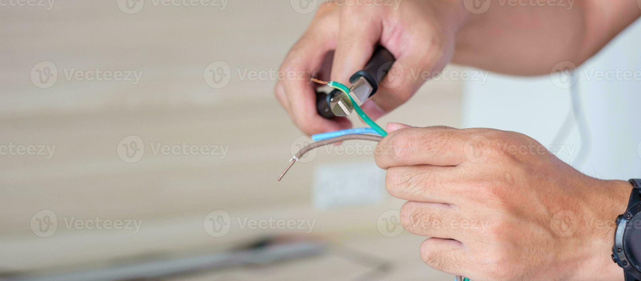 Electrician cuts electrical wires with pliers, Wiring cables installation for socket plug. Fixing, Renovation, Repair, service and development of home and apartment concepts photo