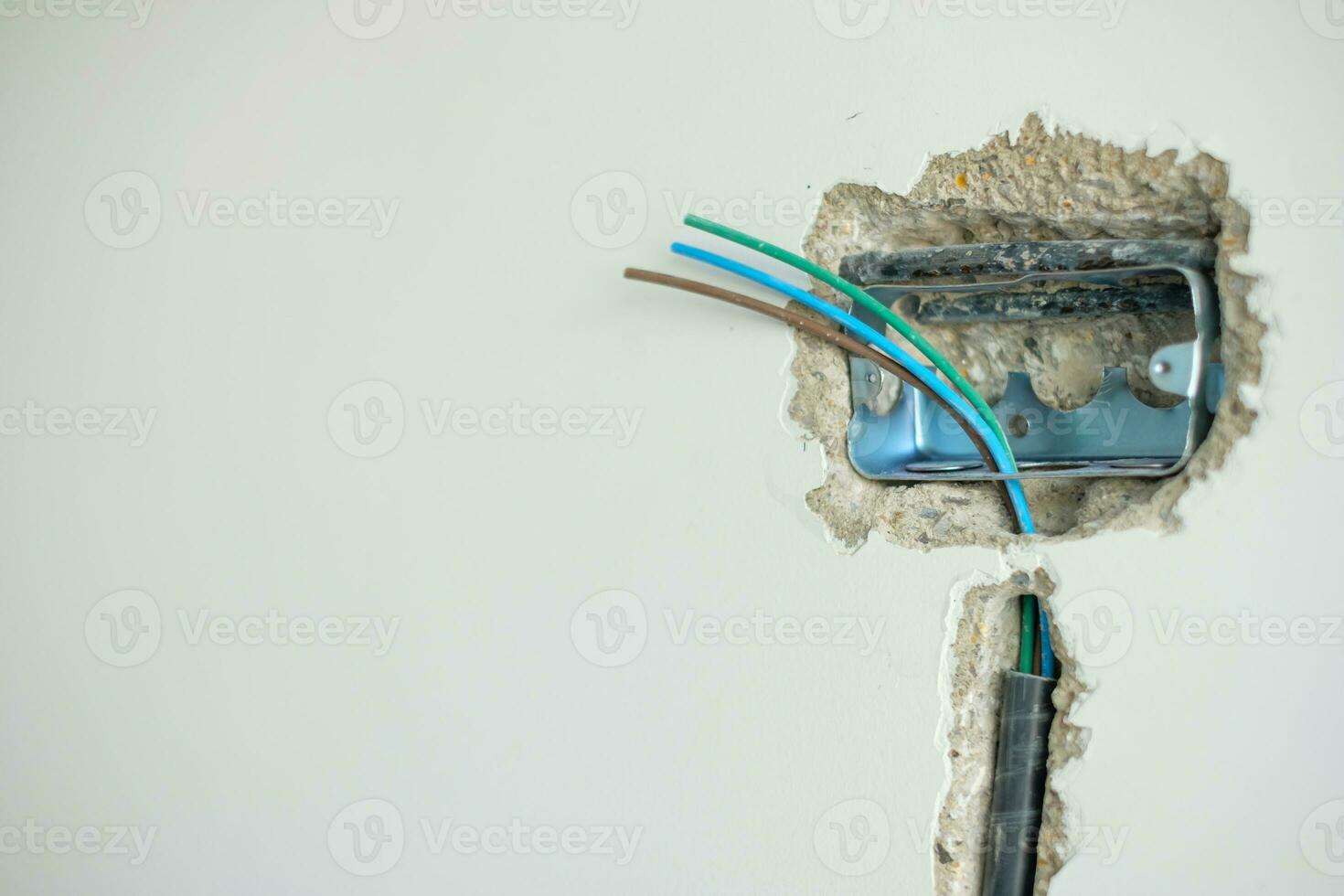 Electrical Wiring under plaster, hidden installation cables for socket to a concrete. Renovation, Repair and development of home and apartment concepts photo