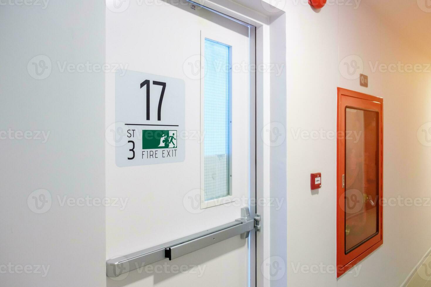 Fire extinguisher system on the wall with Fire Exit door sign for emergency. Stairwell fire for escape in building or apartment photo