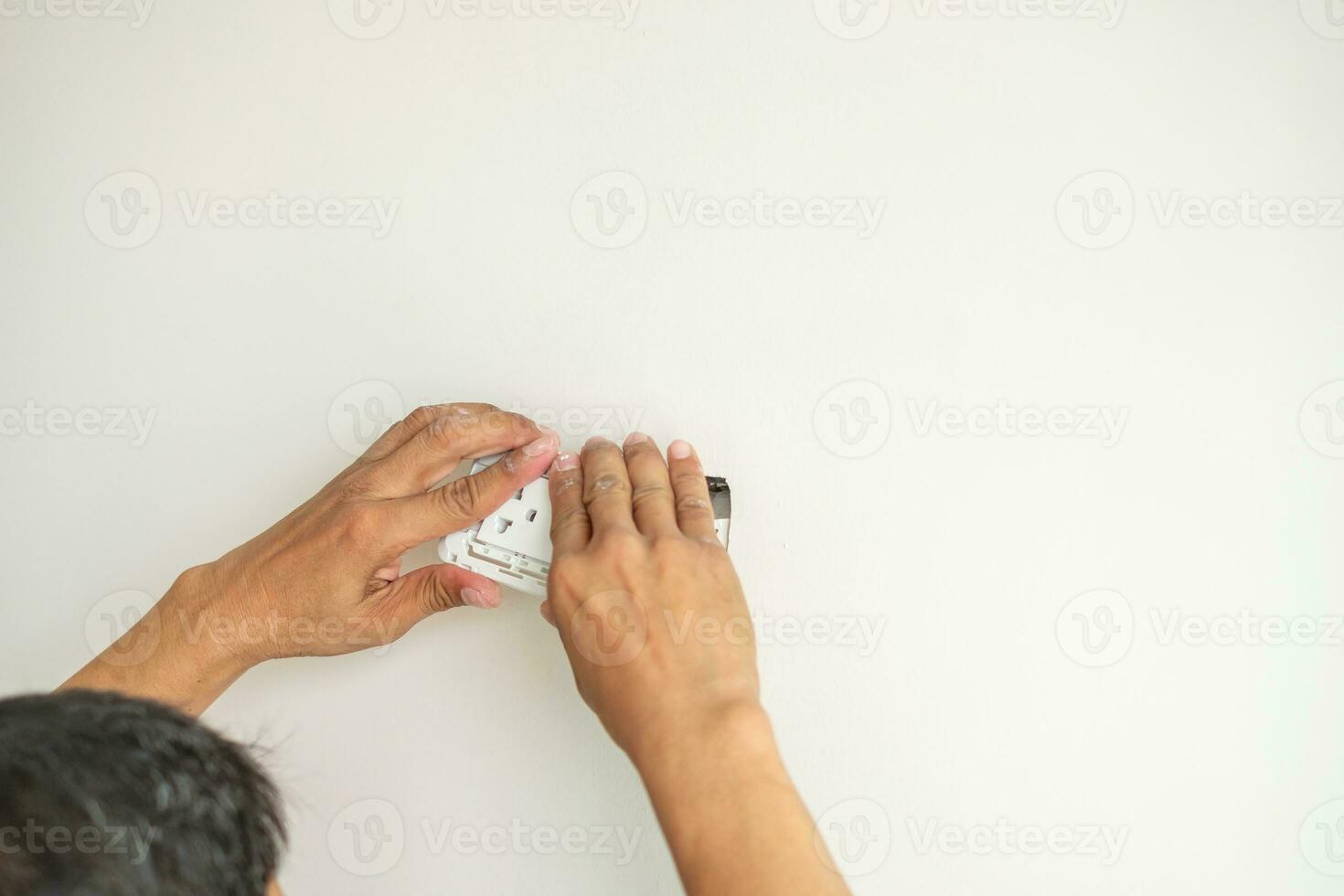 Electrician installing Wire cables for socket plug to a concrete. Renovation, Repair, service and development of home and apartment concepts photo