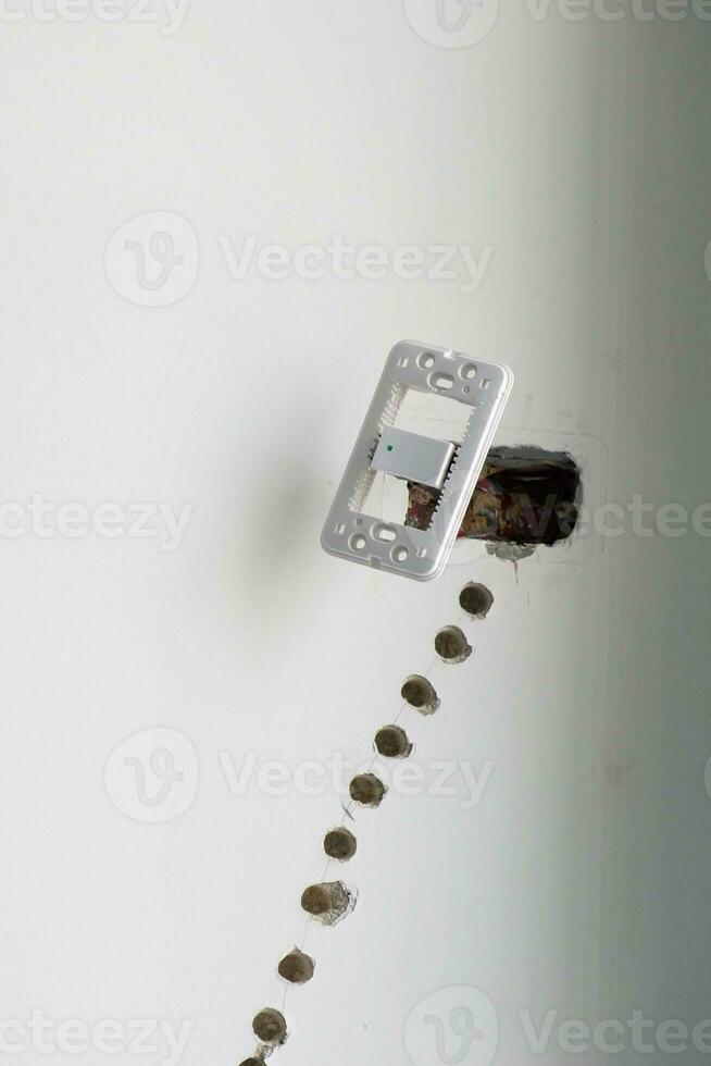 Electrical Wiring under plaster, hidden installation cables for socket to a concrete. Renovation, Repair and development of home and apartment concepts photo