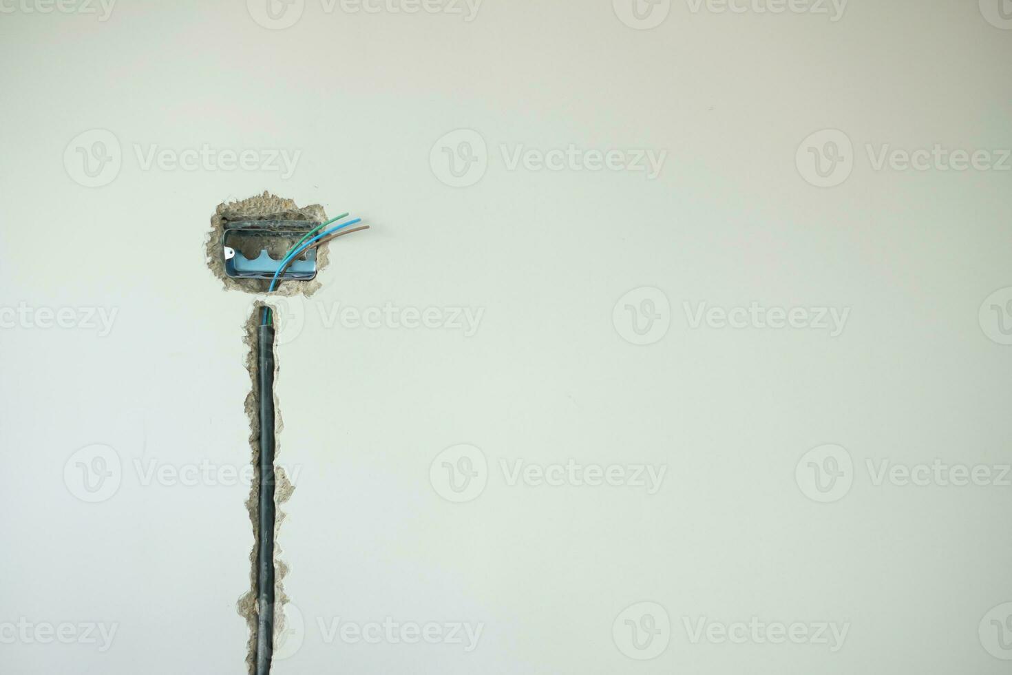 Electrical Wiring under plaster, hidden installation cables for socket to a concrete. Renovation, Repair and development of home and apartment concepts photo