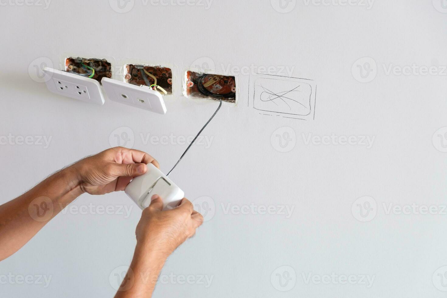 Electrician installing Wire cables for socket plug to a concrete. Renovation, Repair, service and development of home and apartment concepts photo