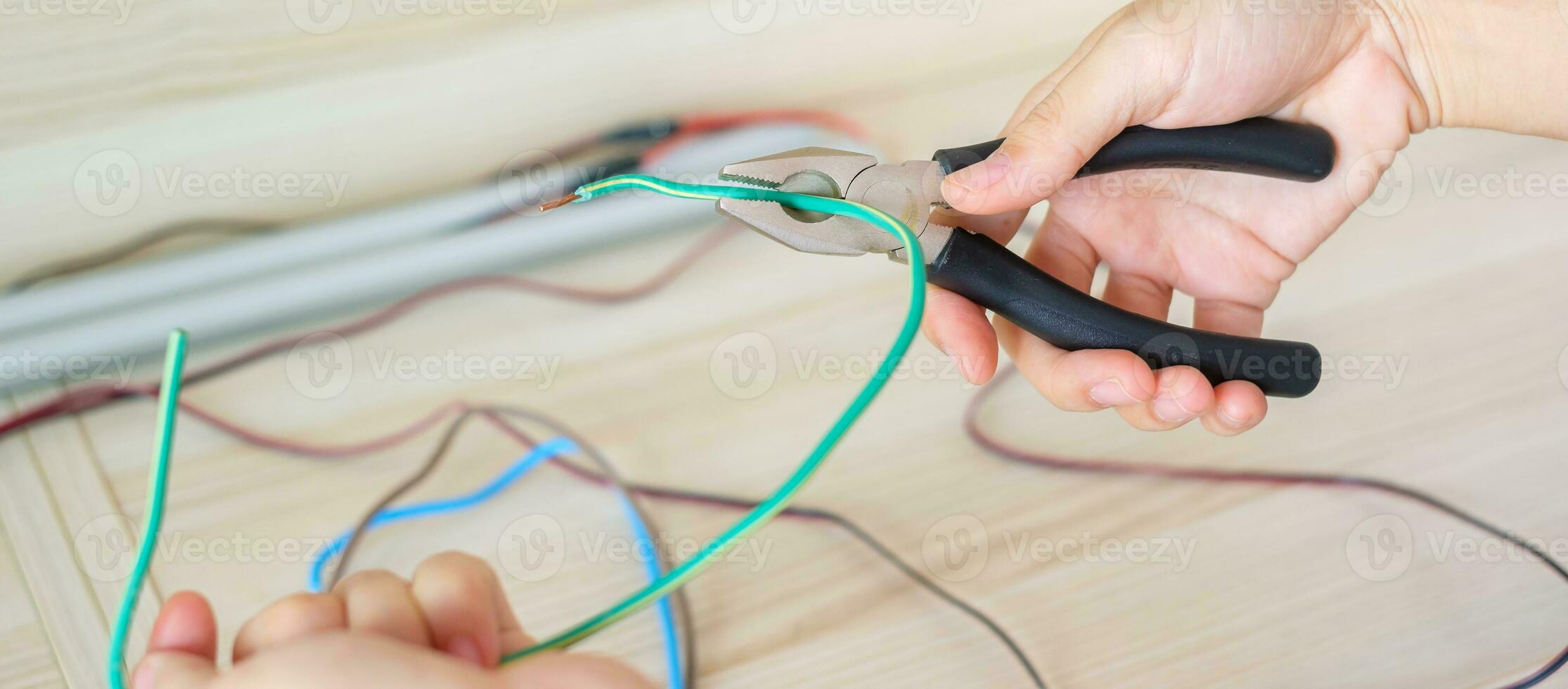 Electrician cuts electrical wires with pliers, Wiring cables installation for socket plug. Fixing, Renovation, Repair, service and development of home and apartment concepts photo