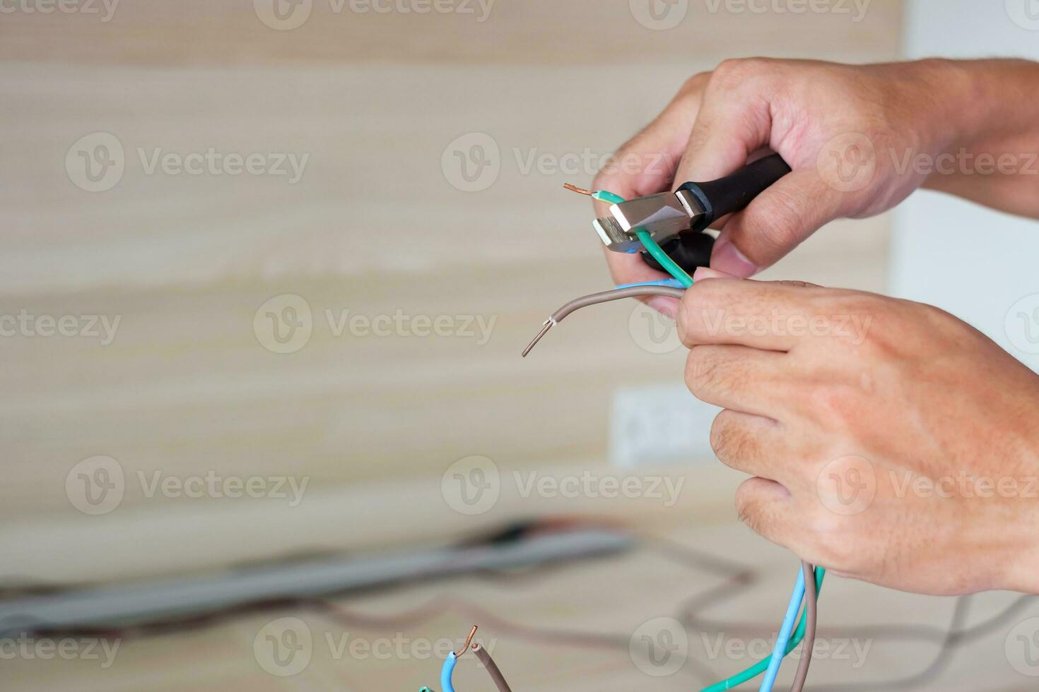 electricista corta cables eléctricos con alicates, instalación de cables de cableado para enchufe. arreglo, renovación, reparación, servicio y desarrollo de conceptos de casas y apartamentos foto